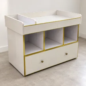 White storage trolley on wheels with a raised top tray, three open cubbies, a wide drawer and gold-tone trim
